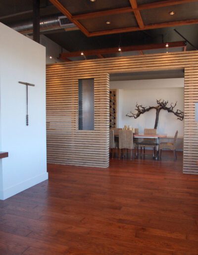 Modern office lobby with wooden slat accents, hardwood floors, and a waiting area with chairs.