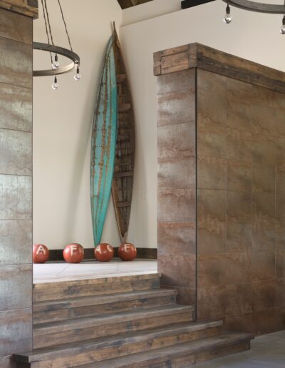 Rustic interior with a mounted surfboard and decorative red spheres.