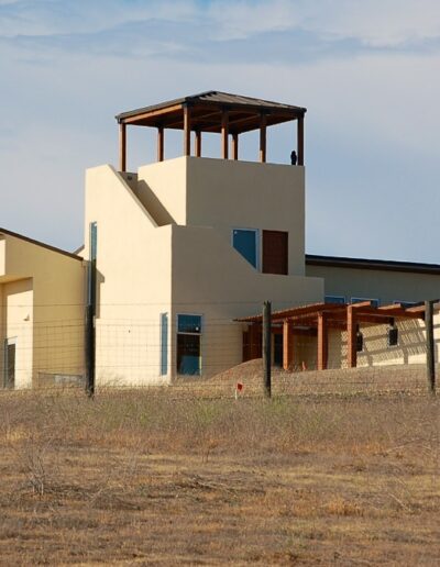 Modern house with tower structure in a dry landscape.