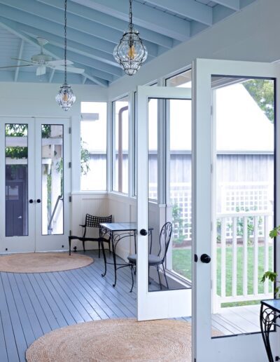 Spacious and airy covered porch with comfortable seating and hanging pendant lights.